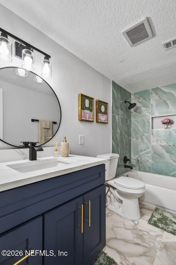 43739 Ratliff Road Callahan, FL 32011 - Photo 36 of 55 a bathroom with a granite countertop sink a toilet and a mirror