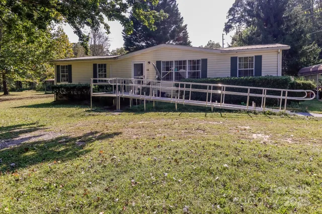 a view of a house with yard and sitting area