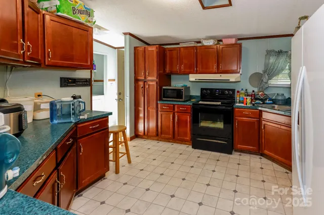 a kitchen with stainless steel appliances granite countertop a stove refrigerator and a sink