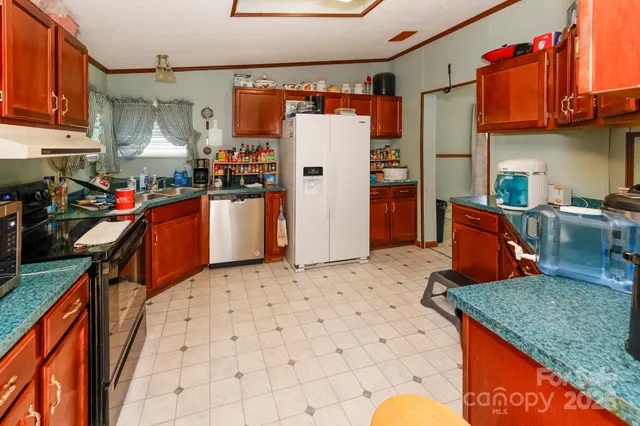 a kitchen with stainless steel appliances granite countertop a sink stove and refrigerator