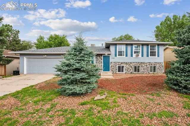 a front view of a house with yard and trees