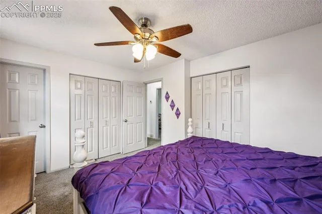 a bed room with a bed and a ceiling fan