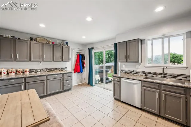 a kitchen with granite countertop a sink stainless steel appliances and cabinets