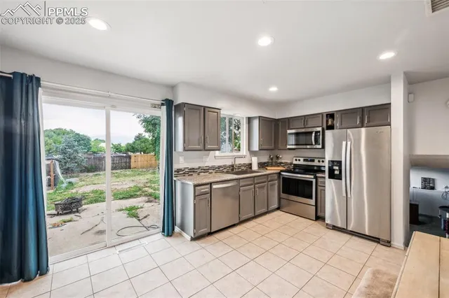 a kitchen with stainless steel appliances granite countertop a refrigerator and a sink