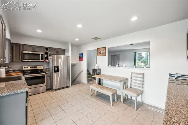 a kitchen with stainless steel appliances kitchen island granite countertop a refrigerator and microwave
