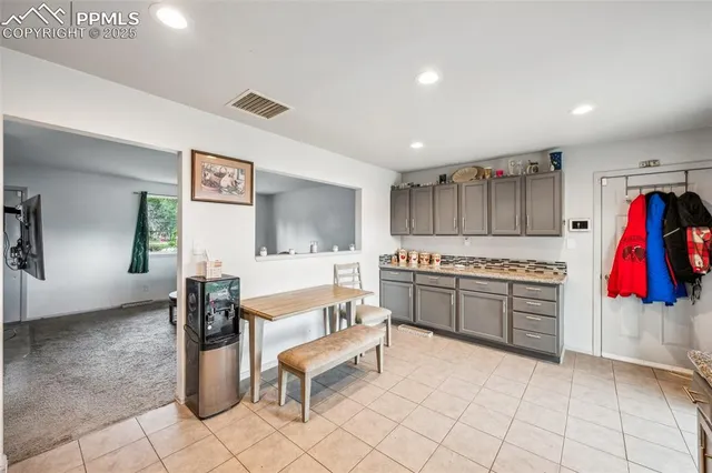 a kitchen with stainless steel appliances granite countertop a kitchen island a stove a dining table and chairs with white cabinets