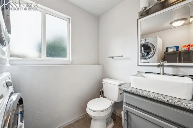 a bathroom with a granite countertop toilet sink and mirror
