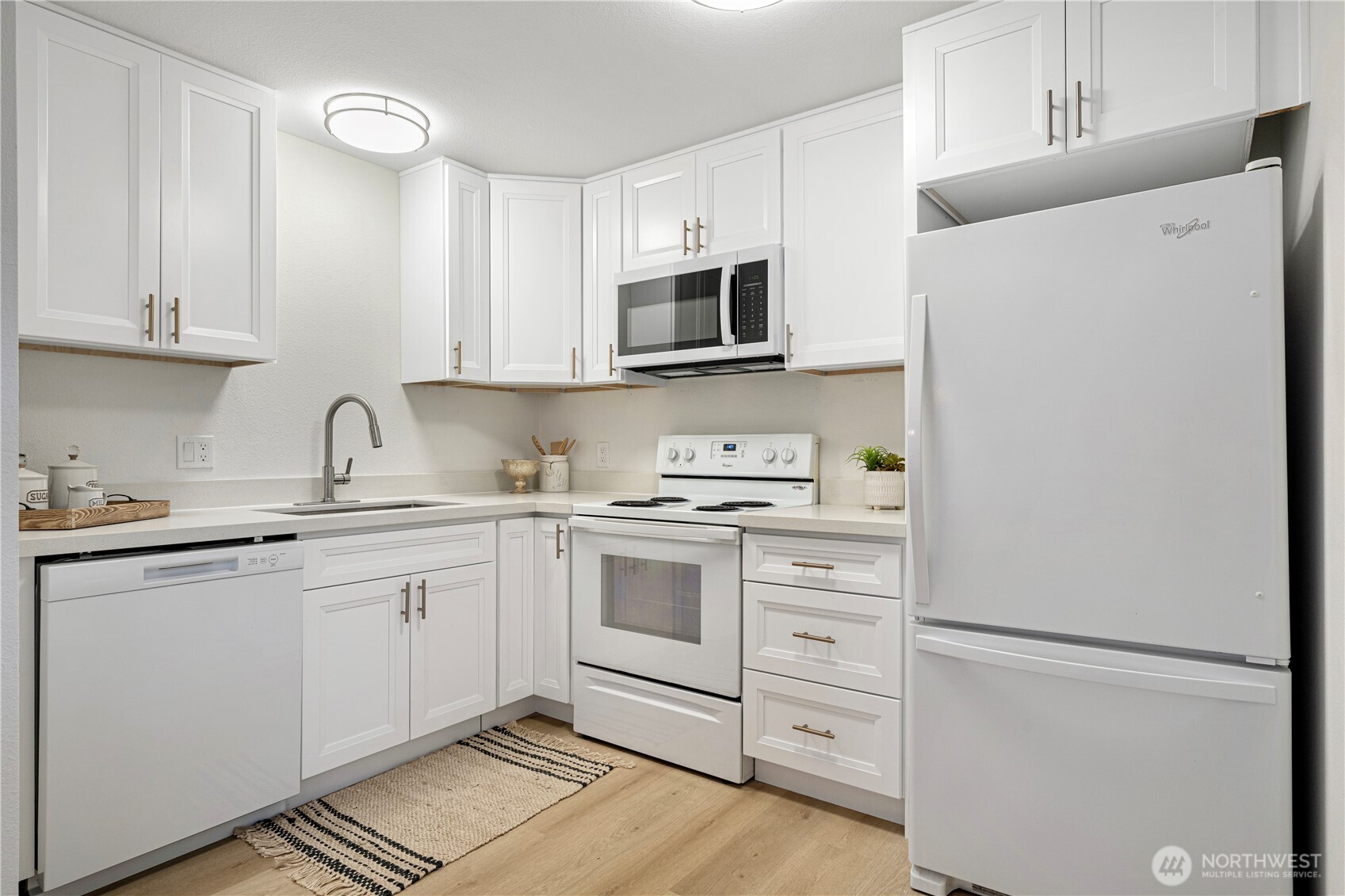 4217 Northeast 5th Street Renton, WA 98059 - Photo 4 of 24 a kitchen with white cabinets and white appliances
