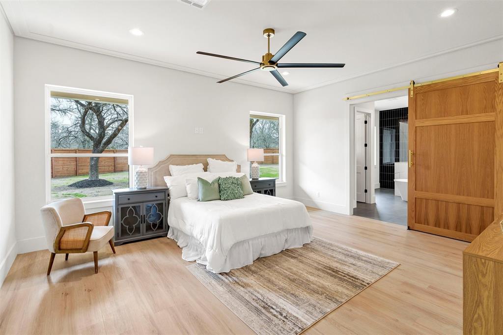 428 Squaw Creek Road Willow Park, TX 76087 - Photo 22 of 34 a spacious bedroom with a bed a couch and a window