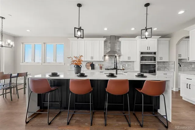 a kitchen with appliances a dining table chairs and cabinets