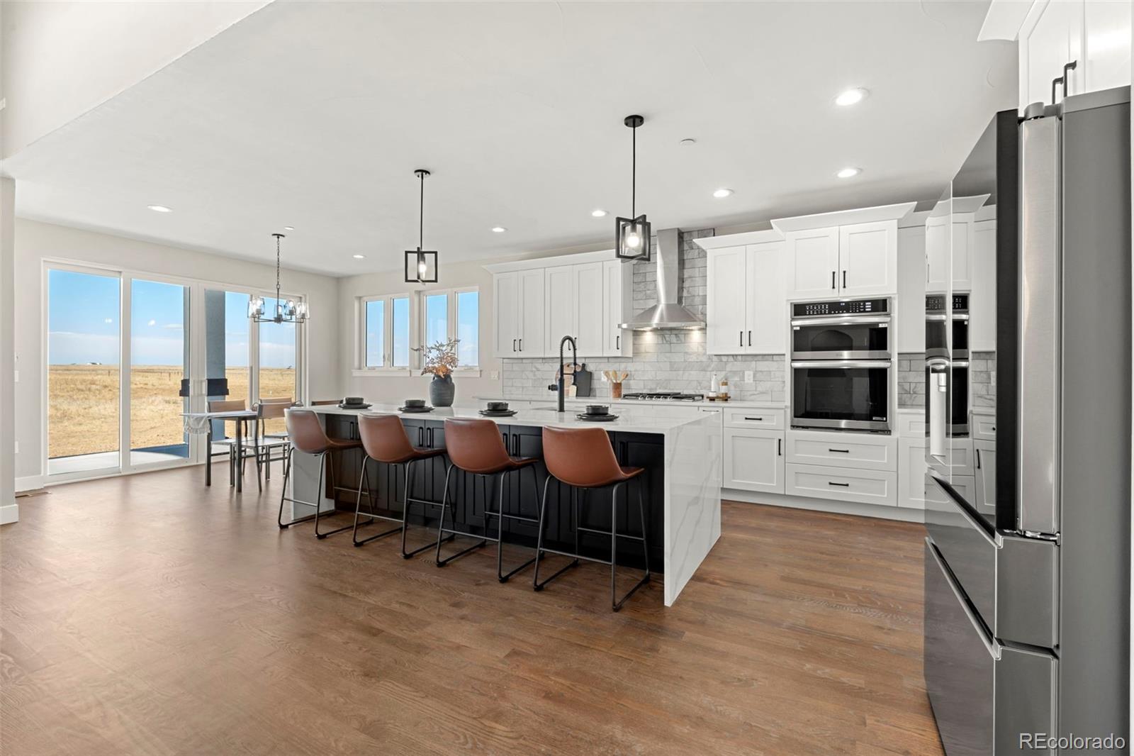12450 Imboden Road Hudson, CO 80642 - Photo 12 of 46 a large kitchen with lots of counter space a sink appliances and a center island