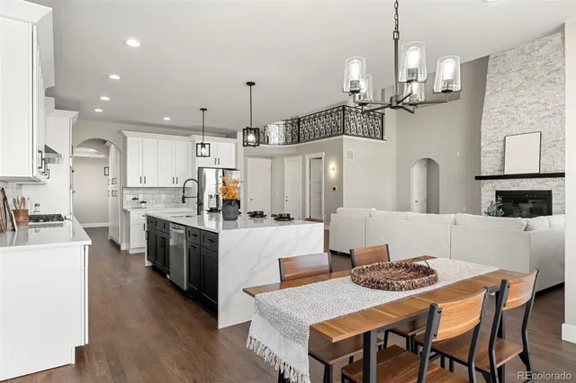 a kitchen with kitchen island a stove a table and chairs in it