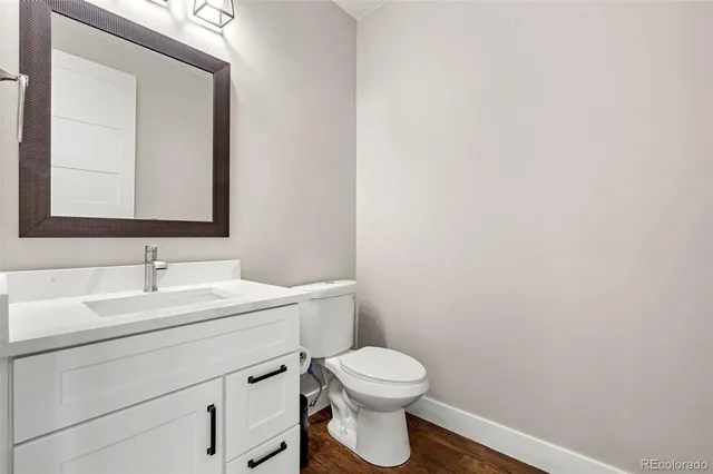 a bathroom with a toilet a sink a mirror and vanity