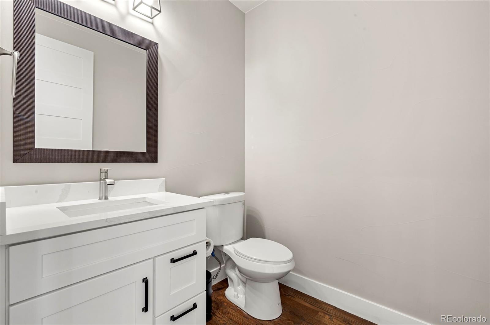 12450 Imboden Road Hudson, CO 80642 - Photo 20 of 46 a bathroom with a toilet a sink a mirror and vanity
