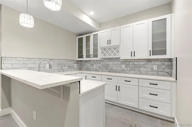 a kitchen with granite countertop white cabinets and white stainless steel appliances