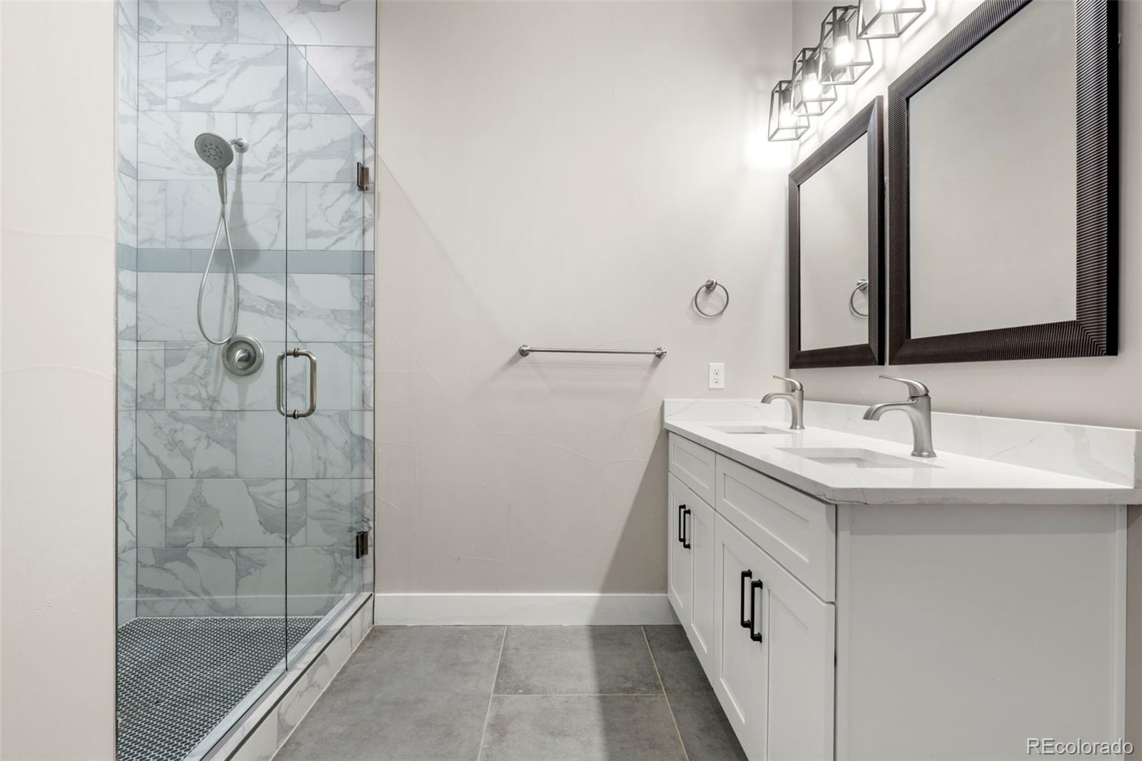 12450 Imboden Road Hudson, CO 80642 - Photo 30 of 46 a bathroom with a double vanity sink mirror and shower