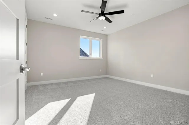an empty room with a ceiling fan and window