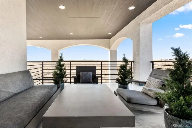 a large living room with furniture a fireplace and potted plants