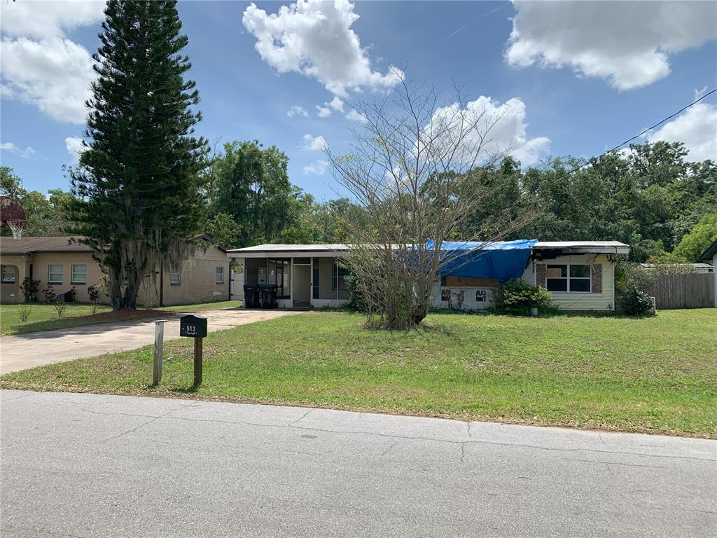 a front view of a house with a garden and trees