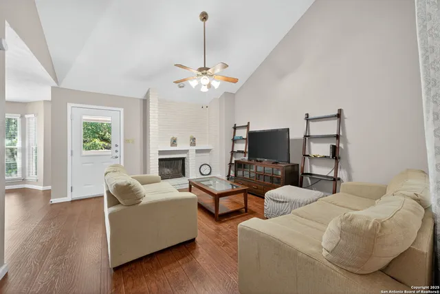 a living room with furniture a fireplace and a flat screen tv