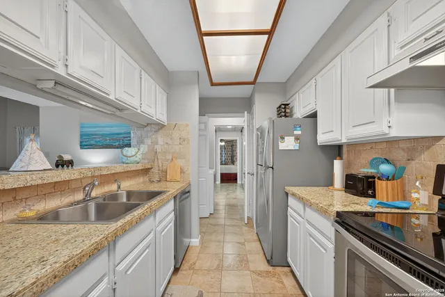 a kitchen with stainless steel appliances granite countertop a sink stove and refrigerator