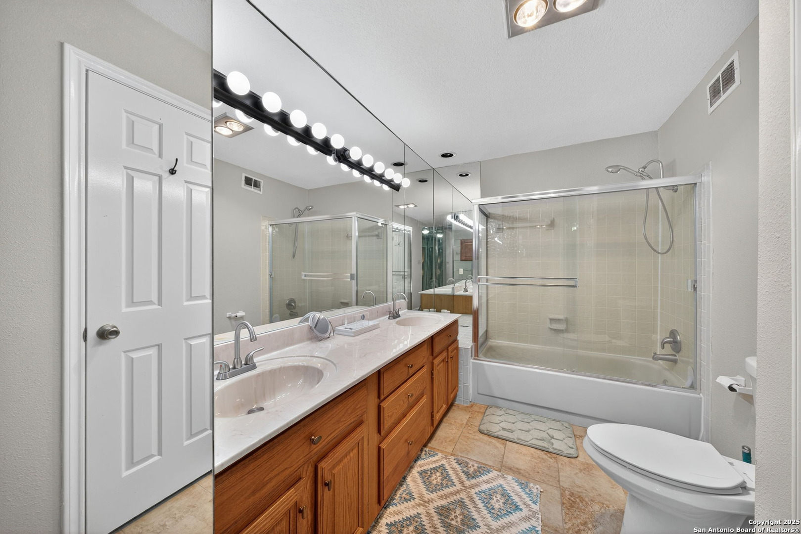 13130 Blanco Road, Unit 206 San Antonio, TX 78216 - Photo 7 of 12 a bathroom with a double vanity sink toilet mirror and bathtub