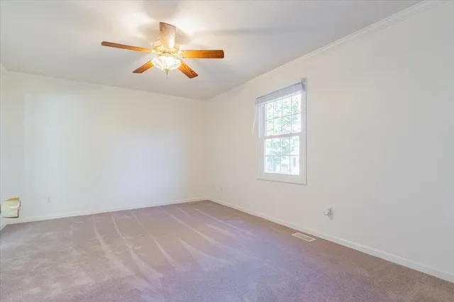 an empty room with a window and a ceiling fan