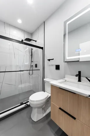 a bathroom with a sink a toilet and shower