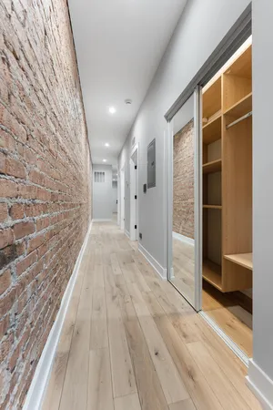 a view of a hallway with wooden floor and entryway