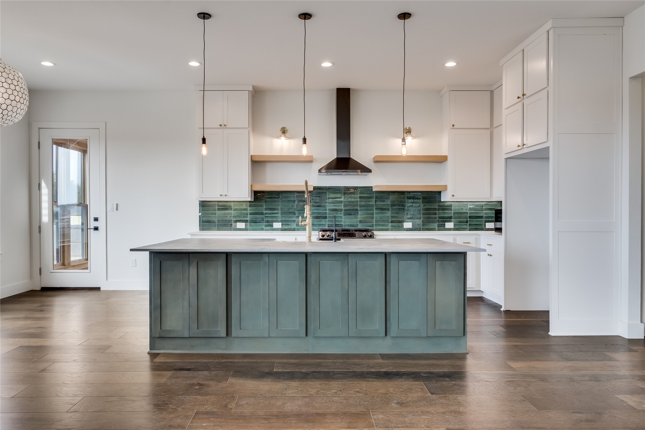 288 Smoke Tree Circle Dripping Springs, TX 78620 - Photo 9 of 40 a kitchen with kitchen island stainless steel appliances a sink cabinets and wooden floor