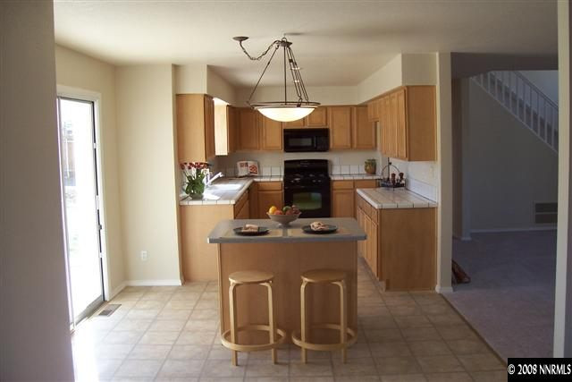 2000 Ron Way Reno, NV 89521 - Photo 3 of 9 a dining room with kitchen island granite countertop furniture a sink a refrigerator and a window