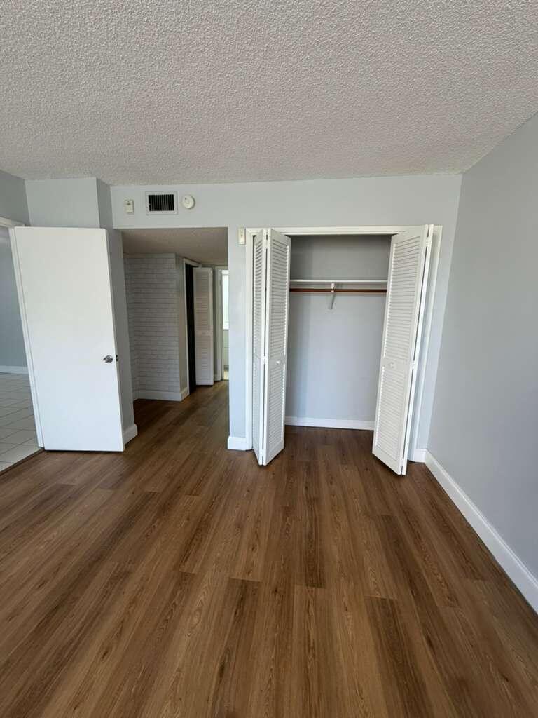 2601 South Course Drive, Unit 203 Pompano Beach, FL 33069 - Photo 19 of 33 an empty room with wooden floor and closet