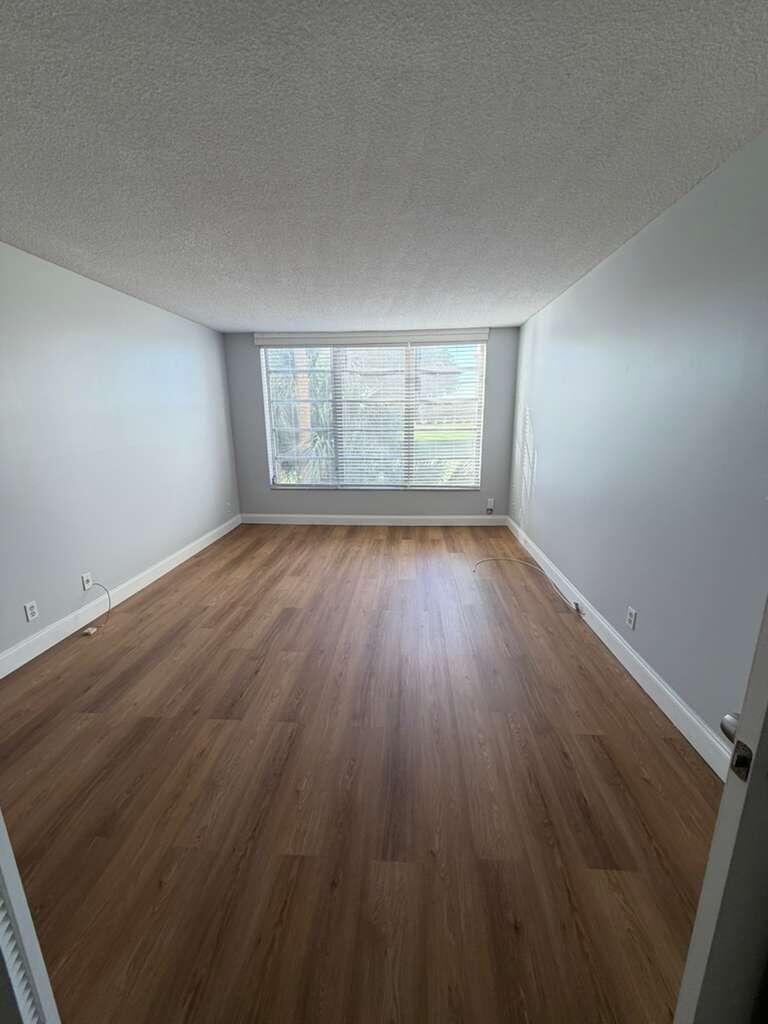 2601 South Course Drive, Unit 203 Pompano Beach, FL 33069 - Photo 21 of 33 an empty room with wooden floor and windows