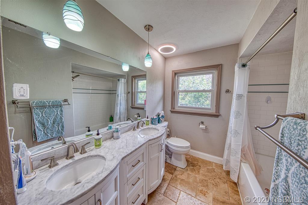 4718 South Atlantic Avenue Ponce Inlet, FL 32127 - Photo 11 of 22 a spacious bathroom with double vanity a toilet a mirror a vanity and a shower