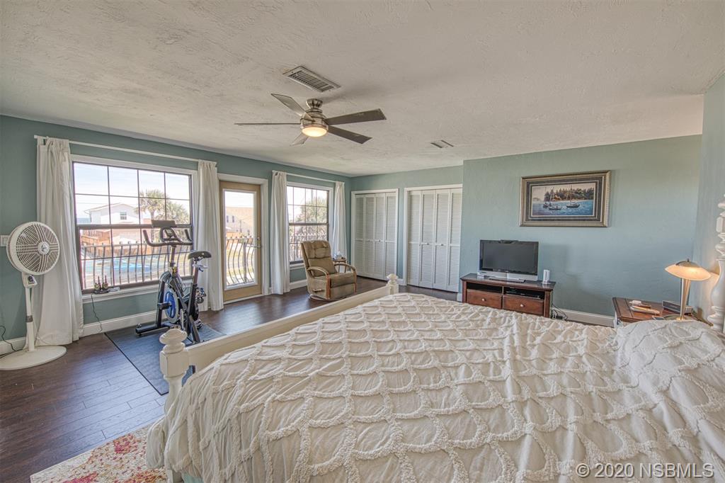 4718 South Atlantic Avenue Ponce Inlet, FL 32127 - Photo 13 of 22 a spacious bedroom with a bed a table and chair