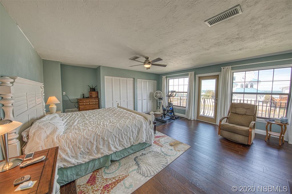 4718 South Atlantic Avenue Ponce Inlet, FL 32127 - Photo 14 of 22 a spacious bedroom with a bed a couch and a large window