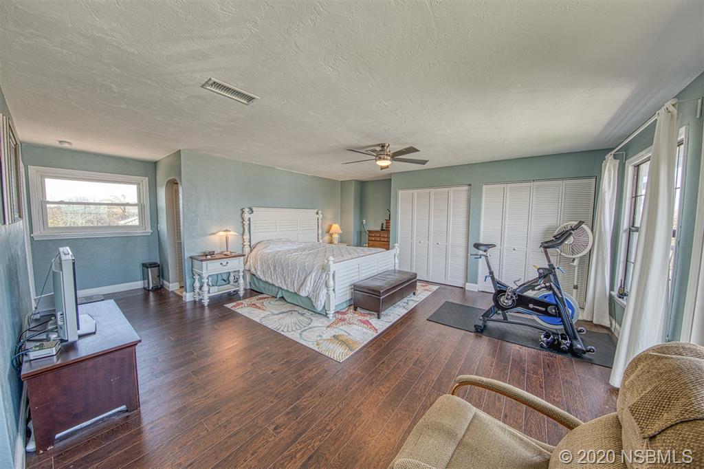 4718 South Atlantic Avenue Ponce Inlet, FL 32127 - Photo 15 of 22 a bedroom with a bed and wooden floor
