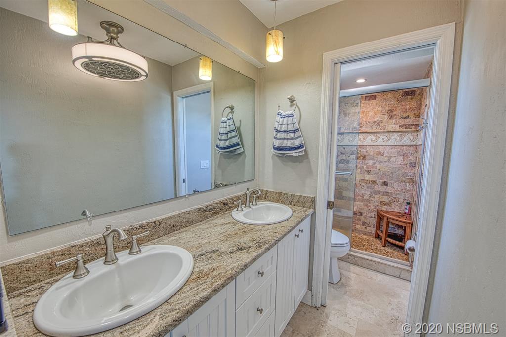 4718 South Atlantic Avenue Ponce Inlet, FL 32127 - Photo 17 of 22 a bathroom with a granite countertop sink toilet and shower