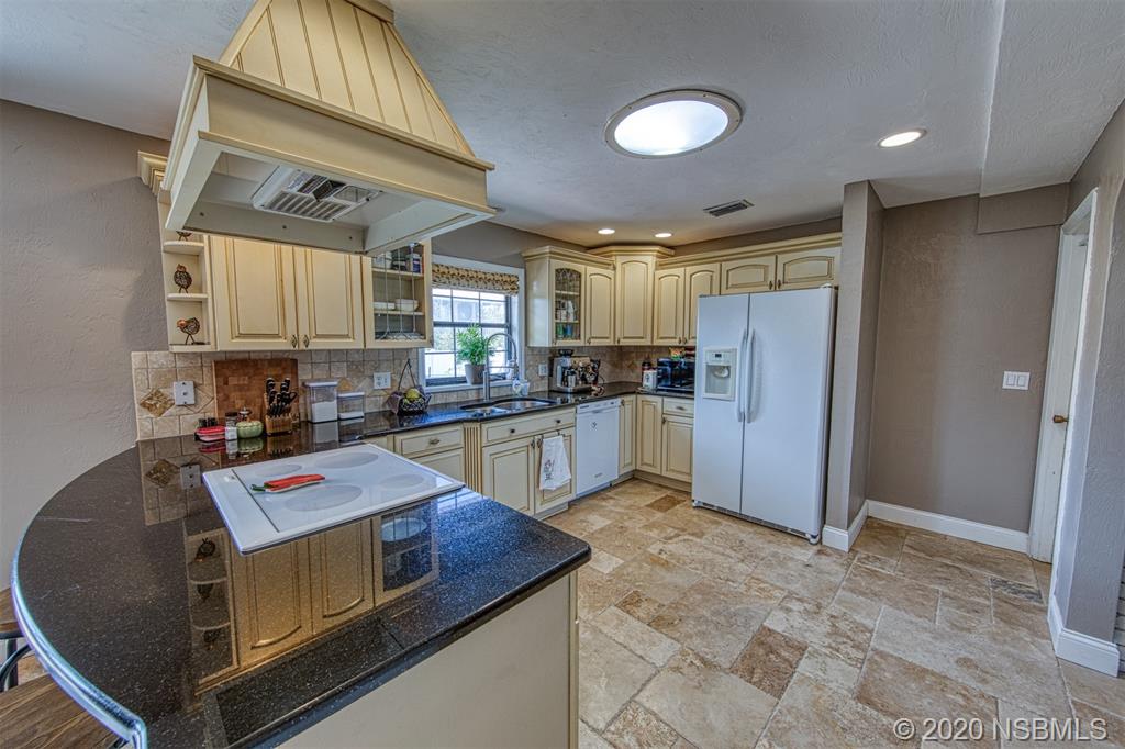 4718 South Atlantic Avenue Ponce Inlet, FL 32127 - Photo 8 of 22 a kitchen with a refrigerator and a sink