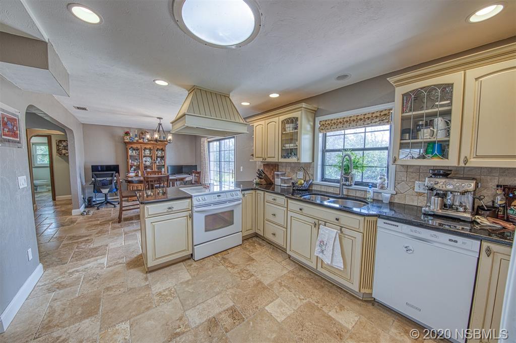 4718 South Atlantic Avenue Ponce Inlet, FL 32127 - Photo 9 of 22 a kitchen with stainless steel appliances granite countertop a sink and cabinets