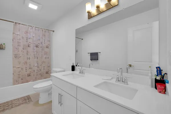 a bathroom with a granite countertop sink a toilet and a bathtub