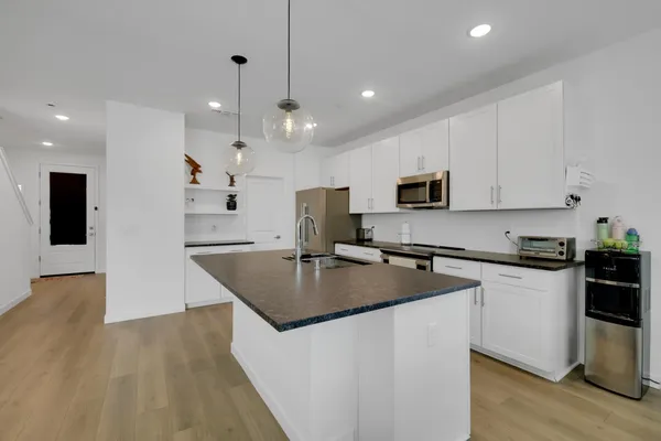a kitchen with appliances cabinets and wooden floor