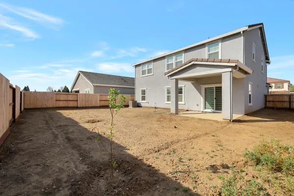 a view of a house with a backyard and a tub