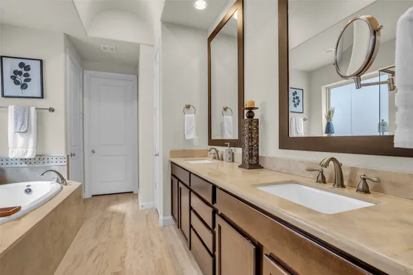a bathroom with a tub a sink and a large mirror
