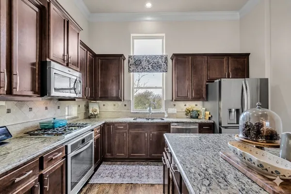 a kitchen with granite countertop a stove and a sink