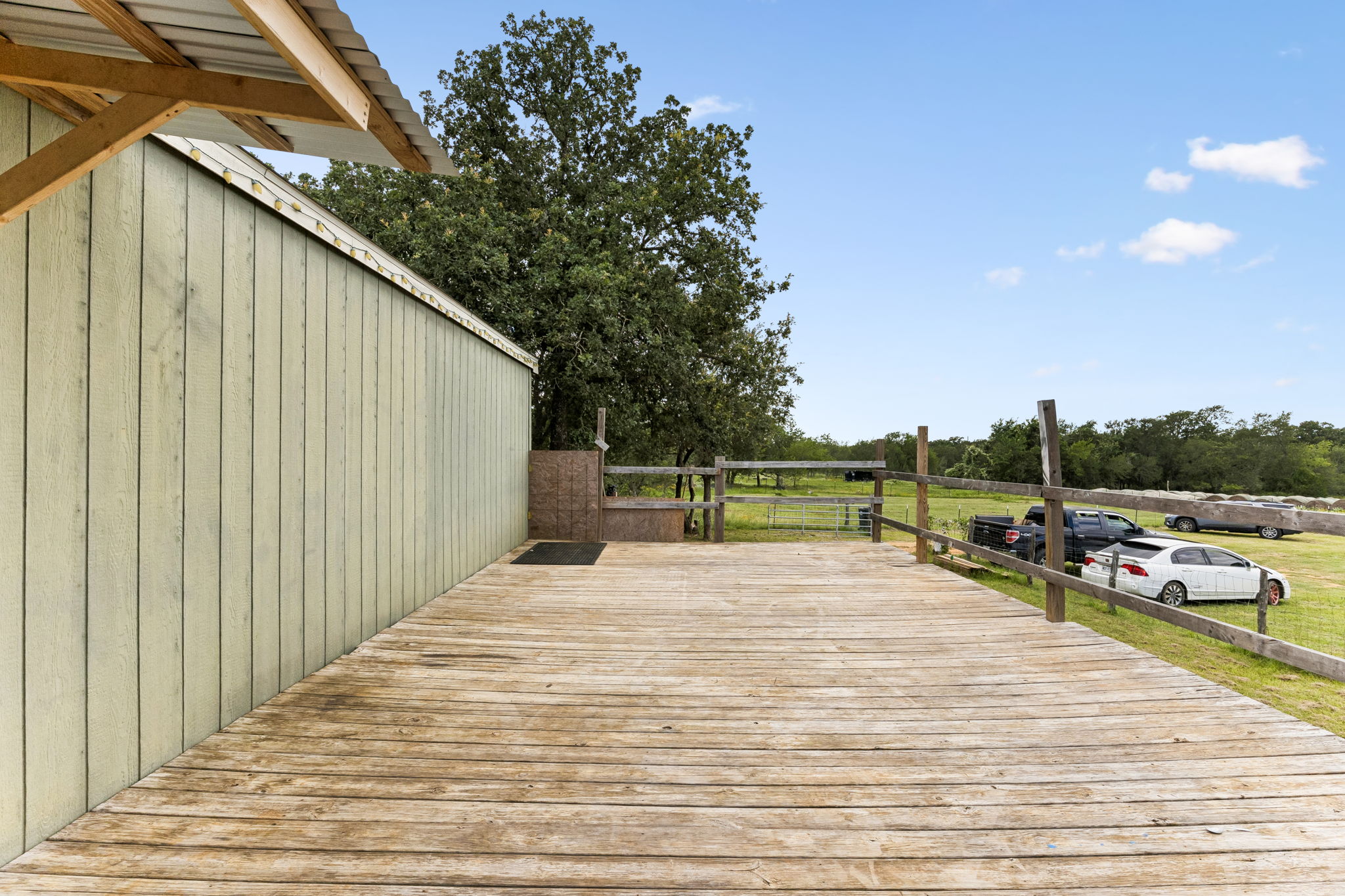 253 North County Line Road, Unit C Elgin, TX 78621 - Photo 5 of 39 A spacious wooden deck provides ample outdoor living space, perfect for enjoying tranquil views of the surrounding land.
