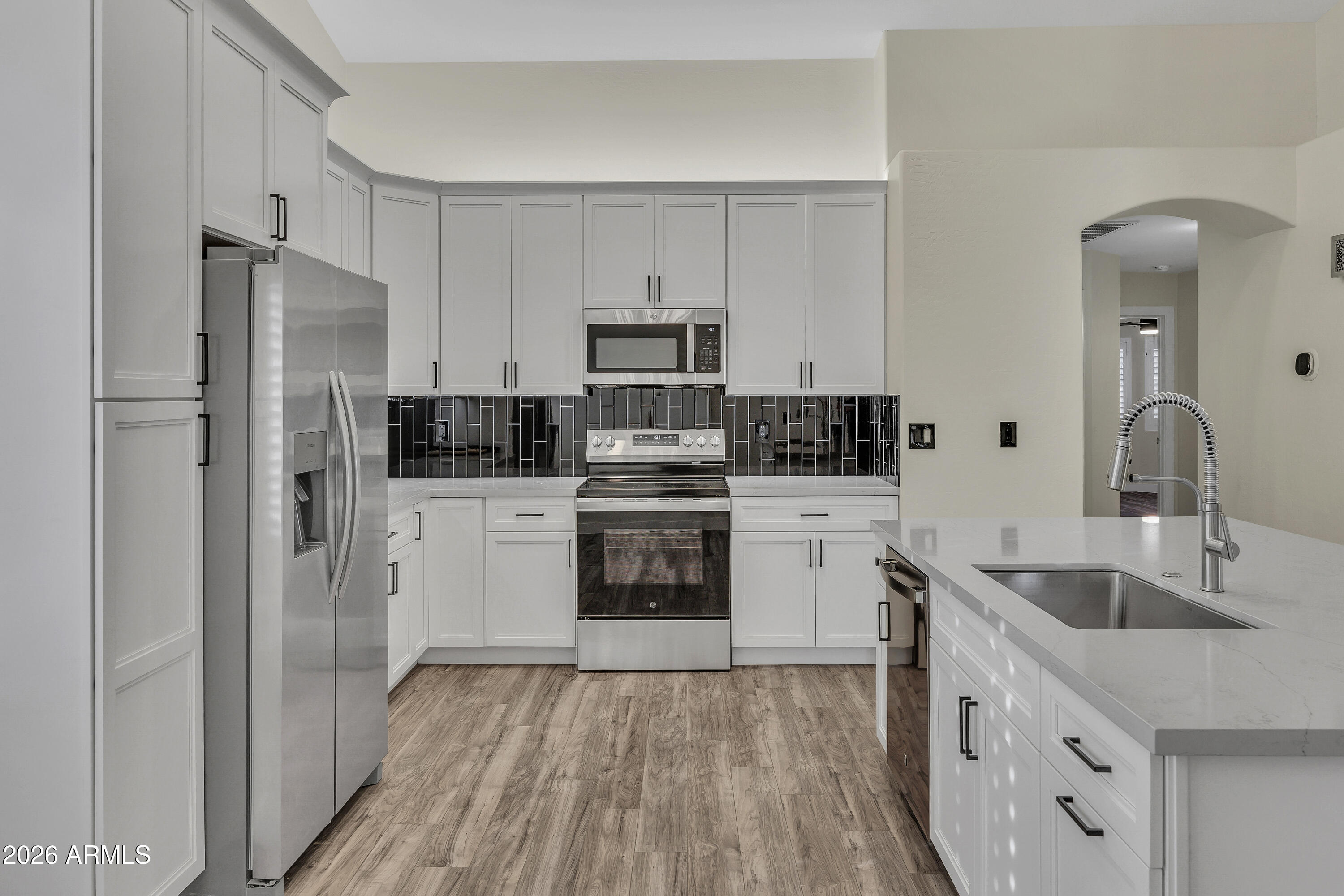 3283 East Bonanza Road Gilbert, AZ 85297 - Photo 3 of 31 a kitchen with white cabinets and stainless steel appliances