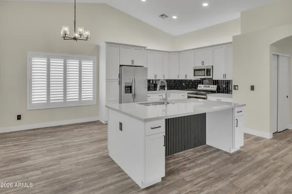 a kitchen with kitchen island granite countertop a sink cabinets and wooden floor