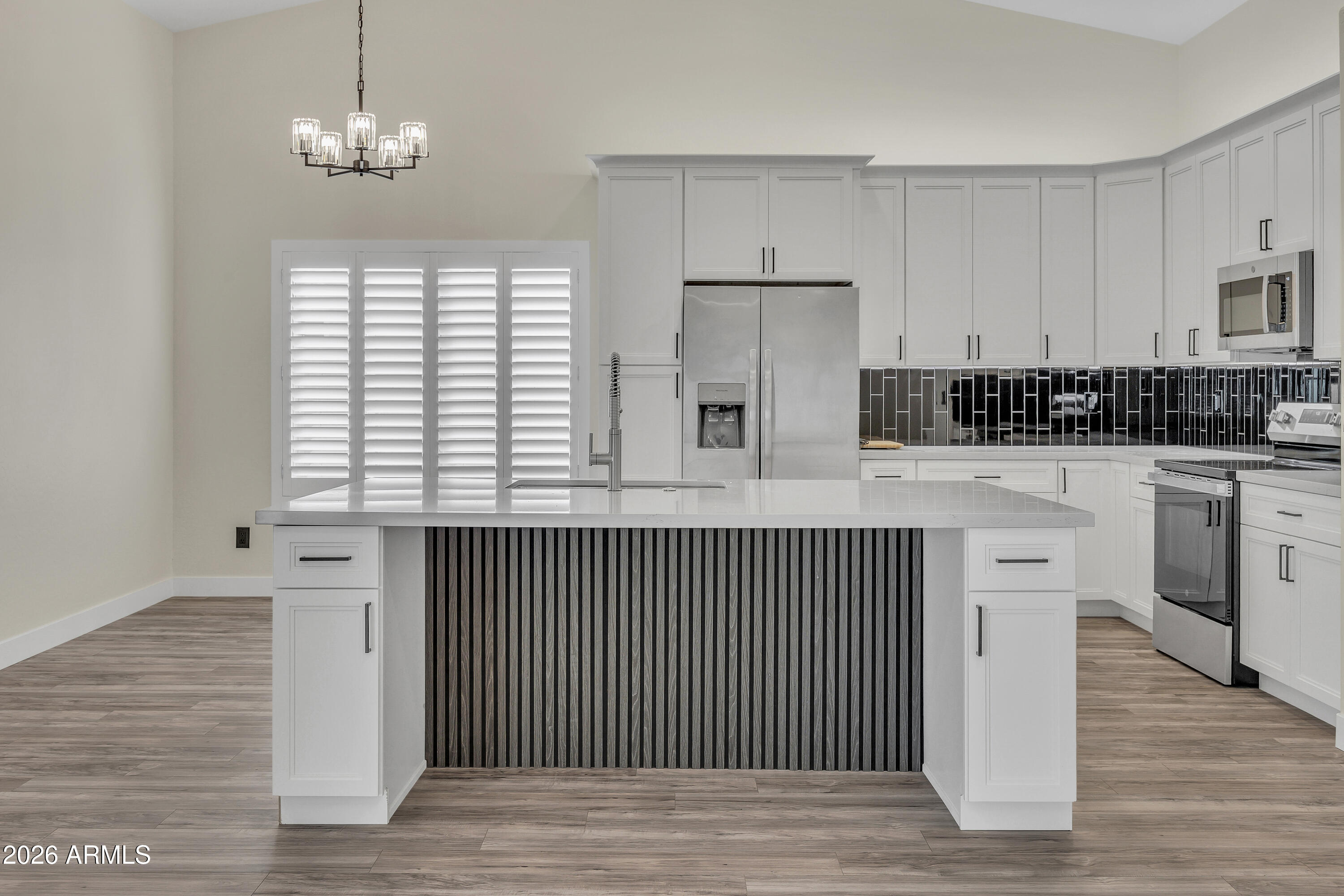 3283 East Bonanza Road Gilbert, AZ 85297 - Photo 6 of 31 a kitchen with stainless steel appliances a white cabinets and a chandelier