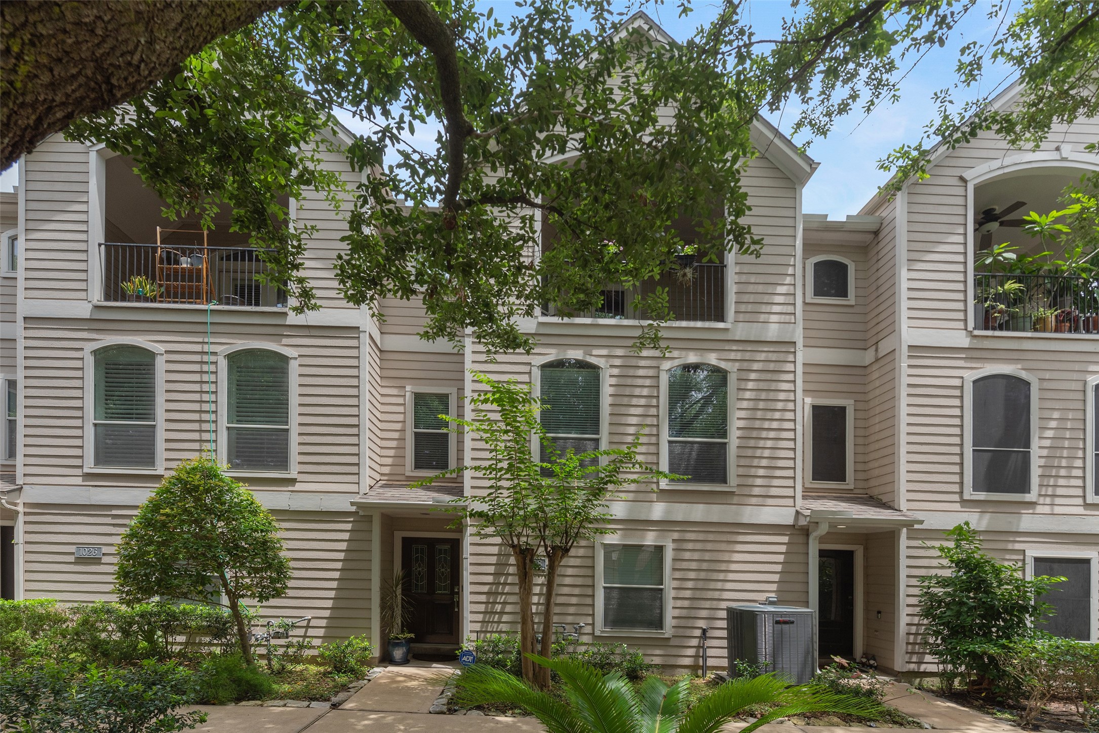 This charming townhousefeatures a three-story designwith a covered balcony and lushlandscaping.